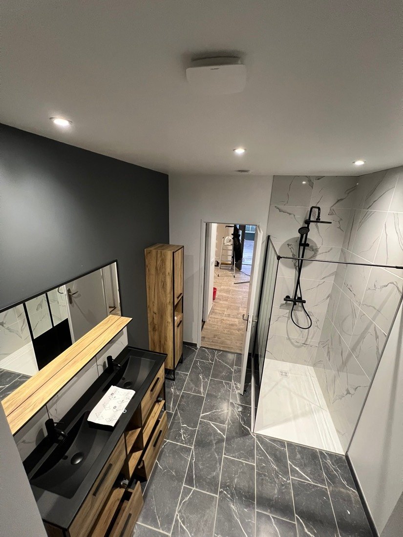 Salle de bain avec double vasque noire et douche effet marbre