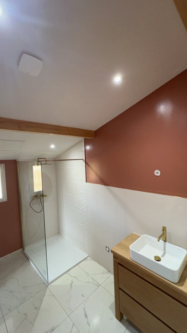 Salle de bain au mur terracotta, vasque à poser et robinet doré